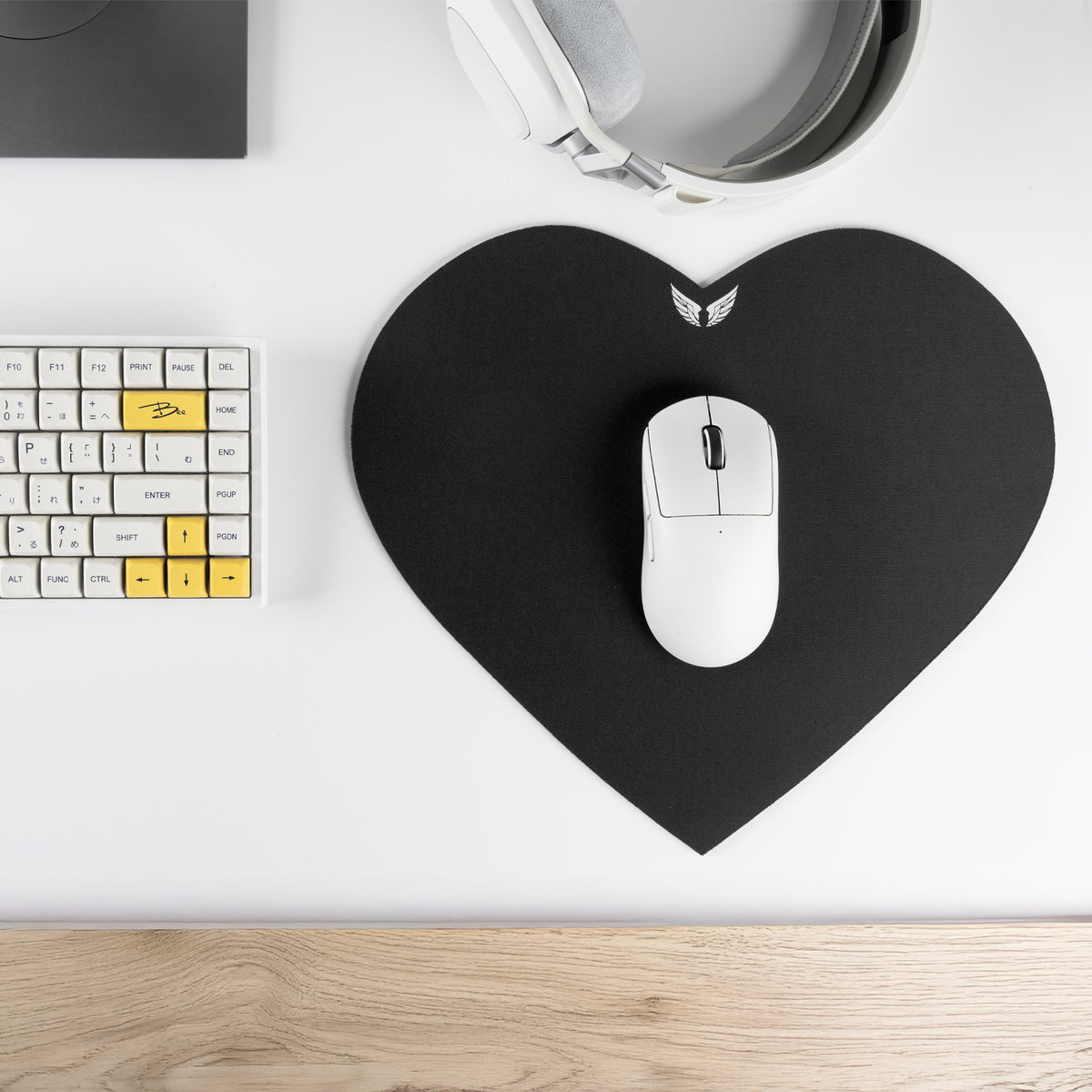 Siyah kalp şekilli GoLite mousepad, klavye ve kulaklıkla masada